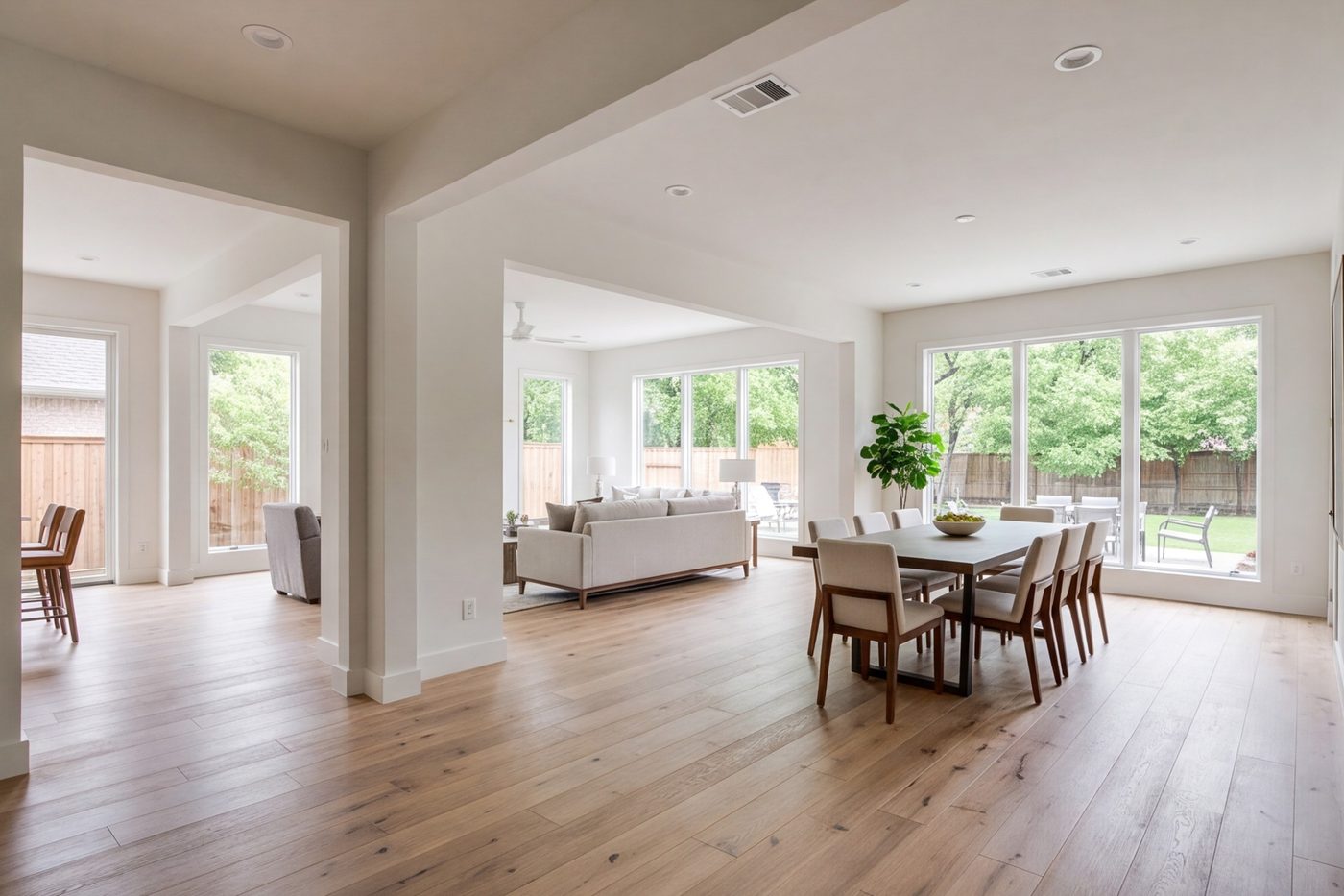 Wide living and dining space with new wood floors and wider openings between rooms